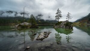 Felsinseln mit Bäumen in einem klaren Bergsee