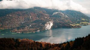 Bergsee mit Felswand und herbstlichem Wald